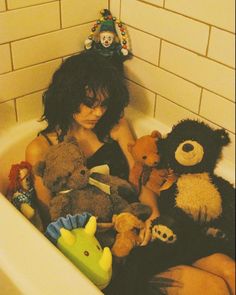 a woman sitting in a bath filled with stuffed animals