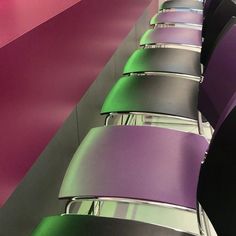 rows of purple and green chairs lined up against a wall