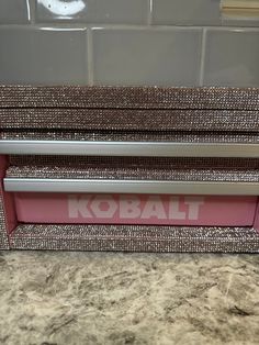 the kobalt logo is on the side of this pink and silver desk organizer