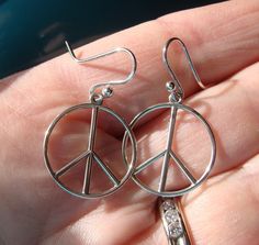 This listing is for light weight sterling silver peace signs that I hang on hand made and heat forged sterling silver ear wires.  They are bright and shiny. They are about 18mm wide. The last photo shows the same size sign that I also make in a post style and they can be found here  https://www.etsy.com/listing/775574889 Symbolic Silver Jewelry With Peace Sign, Peace Sign Jewelry For Gifts, Silver Peace Sign Jewelry Gift, Symbolic Round Peace Sign Jewelry, Adjustable Sterling Silver Peace Sign Jewelry, Silver Earrings Drop, Peace Sign Jewelry, Mermaid Artwork, Peace Signs