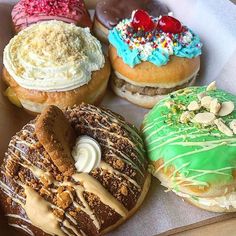 a box filled with different types of donuts on top of each other and covered in frosting