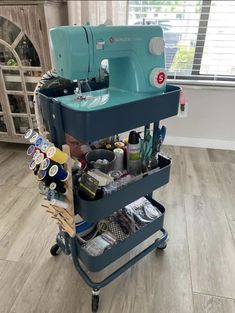 a sewing machine sitting on top of a cart filled with crafting supplies and other items