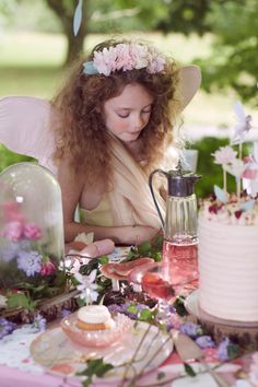 a woman sitting at a table in front of a cake