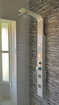 a shower head with thermostaer and faucet in a modern bathroom