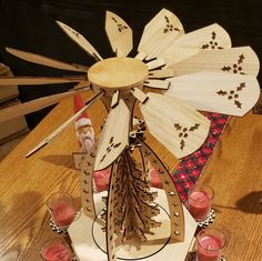 a wooden windmill with candles on a table