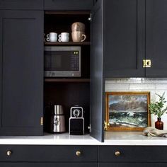 a kitchen with black cabinets and white counter tops