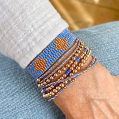 A Solid Statement Band: Flat woven; 1/2"w; 14K yellow/rose gold-filled or sterling silver clasp & 1" extender chain; glass seed beads. Strands: Stretch style; 14K yellow/rose gold-filled or sterling silver round 2mm, 3mm & 4mm beads; glass seed beads. Wrap: Stretch style that will wrap around the wrist 3 times (can also be worn as a necklace); glass seed beads. (When adding to cart, select your single bracelet size, and it will be multiplied in length by three when made). Shown in rose gold; als Elegant Blue Friendship Bracelets With Colorful Beads, Elegant Blue Friendship Bracelets With Round Beads, Elegant Blue Beaded Friendship Bracelets, Adjustable Blue Friendship Bracelets With Gold Beads, Blue Beaded Bracelets With Tiny Beads For Everyday, Blue Braided Bracelets With Tiny Beads As Gift, Everyday Blue Beaded Bracelets With Tiny Beads, Blue Tiny Beads Friendship Bracelets, Everyday Blue Bracelets With Gold Beads