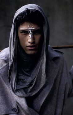 a man wearing a hood and scarf with an eye patch on his forehead