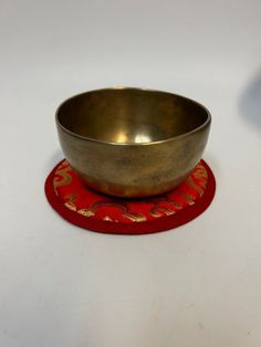 a metal bowl sitting on top of a red coaster