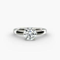 a round brilliant cut diamond engagement ring on a white background with clippings to the side