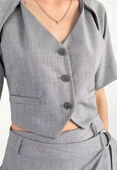 One size. Fits XS-MColor: Heather GreyLinedAdjustable Waist Back TieButton Down FrontCropped LengthTwo Front Pockets (Non Functional)Short Sleeve Cape Detail63% Polyester 30% Rayon 7% SpandexDry CleanBy The NKC StoreMeasurements:Bust: 81.28cm / 32inLength: 38cm / 15in Fitted Gray Tops With Pockets, Gray Fitted Tops With Pockets, Tailored Button Tops, Shirts Crop Tops, Woman Vest, Dallas Fashion, Outerwear Vest, Knit Tank, Knitting Women