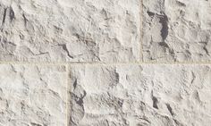 a white stone wall with cracks in it