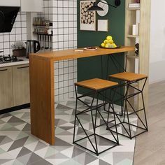 two stools sitting at a kitchen table in front of a green wall with white and black tiles