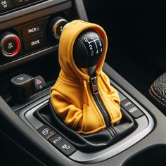 a yellow hoodie sitting on the center console of a car with an air vent