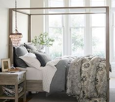 a bedroom with a four poster bed and chandelier hanging from it's ceiling