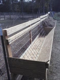 a wooden fence with wire on it and some grass in the back ground next to it