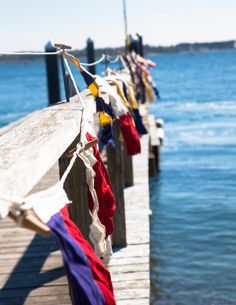 colorful clothes hanging on a wooden dock by the water