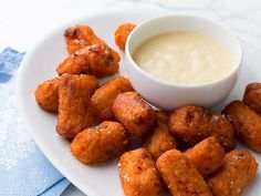 a white plate topped with tater tots next to a bowl of ranch dressing