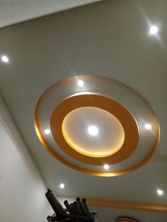 a circular light fixture in the middle of a room with white walls and ceiling lights