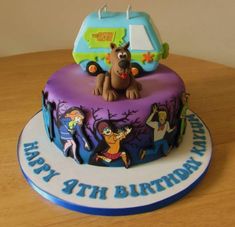 the birthday cake is decorated with cartoon characters and has a dog on it's top