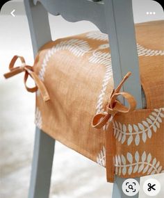 an upholstered chair with a bow tied around the back and seat padding