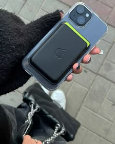 a person holding up an iphone case with a chain attached to the back of it