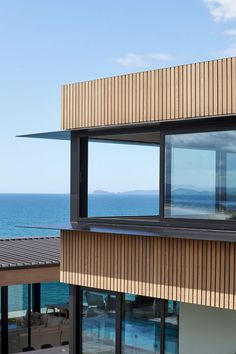 an ocean view is seen through the windows of a modern house by the water's edge