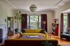 a living room filled with furniture and a fire place in front of a large window