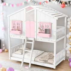 a white bunk bed with pink doors and windows on the top floor, next to balloons and streamers