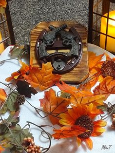 a table topped with lots of fake sunflowers and other autumn decorating items