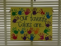 a sign that says our favorite colors are handprinted on it and hanging from the window sill