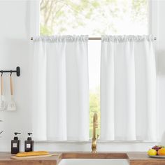 a kitchen window with white curtains and utensils