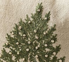 an embroidered christmas tree on a piece of linen