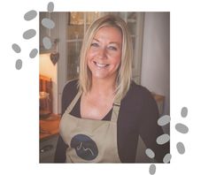 a woman wearing an apron and smiling at the camera