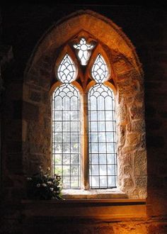 an old stone building with two stained glass windows