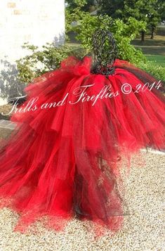 a red tulle skirt with black lace on the top and bottom, sitting in gravel