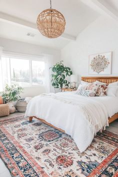 Bright bedroom with a woven light fixture, white bedding, a large plant, and a colorful rug. Mid Century Boho Bedroom, Chic Boho Bedroom, Boho Chic Interior Design, Cozy Eclectic, Boho Style Room, Bedroom Eclectic, Bohemian Decor Inspiration