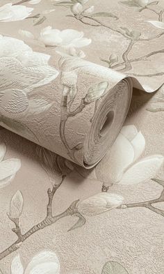 a roll of toilet paper sitting on top of a flowery wallpaper covered floor