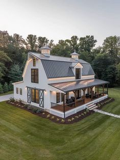 a large white house in the middle of a green field