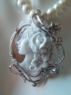 "This is a beautiful modern master hand carved sardonyx cameo by the artist, Carla. This is a very complex and intriguing piece and the design makes it an absolutely amazing piece of work. All the detail is exceptionally done to perfection! The right cameo is cameo is 48 mm mm (1.89\") and it is set into Italian silver with a 6 mm enhancer bail and a pin attachment. It comes packed in a black velvet box and certificate of authenticity for gift giving. Welcome to CASCO Cameos, LLC. CASCO Cameos i Luxury Cameo Pendant Jewelry, Elegant Carved Oval Jewelry, Elegant Mother Of Pearl Medallion Necklace, Elegant Medallion Necklace In Mother Of Pearl, Elegant Oval Carved Jewelry, Elegant Cameo Jewelry For Formal Occasions, Elegant Oval Pendant Necklace For Collectors, Luxury Cameo Medallion Jewelry, Carved White Sterling Silver Necklaces