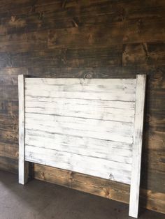 the headboard is made out of wood and has white paint on it's sides