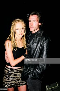 a young man and woman posing for the camera in front of a black background stock photo