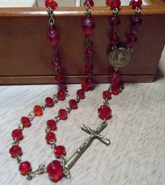 Handmade Rosary with Brass Crucifix and medallion, Czech Preciosa Crystal Beads in Red Ruby & Red Glass Flower Beads. Rose Beads. Please note: All Props, Clothing, Wigs, Mannequin, purses, jewelry boxes, etc. are NOT included with the purchase of this listing. The dollar amount specified for sale, only includes the Rosary that is described above.  Always check the top of my Announcement page for any available coupon codes. If you have a coupon or a gift certificate, the code must be put in the c Vintage Red 8mm Beaded Jewelry, Vintage Red Jewelry With 8mm Beads, Handmade Red Rosary For Jewelry Making, Adjustable Red Beaded Rosary, Red Rosary Beads For Jewelry Making, Red Beaded Rosary With Round Beads, Silver Leaf Bracelet, Handmade Rosary, Shoulder Duster Earrings