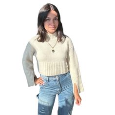 Embrace a playful yet chic look with our Cropped Bell Sleeve Sweater. Its cropped cut and bell sleeves make it perfect for pairing with high-waisted jeans or skirts. Ideal for adding a trendy touch to your wardrobe. Shop more Sweaters Model is wearing a small Shop more colors Cream Cropped Fuzzy texture Ribbed knit Sleeve slits Mock neck Thick rib knit trim 73% acrylic, 14% nylon, 10% wool, 3% spandex Still not sure which size to get? Ask one of our stylists! Please give us a call at 856-452-582 White Cropped Hem Tops For Fall, Chic Cropped Sweater For Spring Day Out, Chic Cropped Sweater For Fall, Chic Cropped Crop Top For Fall, White Stretch Cropped Sweater Trendy, White Stretch Cropped Sweater Trendy Style, Trendy White Stretch Cropped Sweater, Casual High Waist Crop Top For Fall, Trendy Knit Cropped Sweater