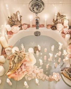 a bathtub filled with candles and sea shells