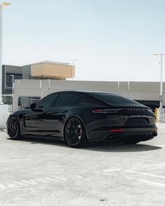 a black sports car parked in an empty parking lot