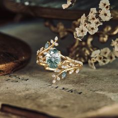 a close up of a ring on top of a book with flowers in the background