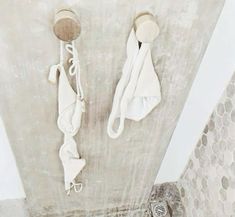 two white towels are hanging on the wall