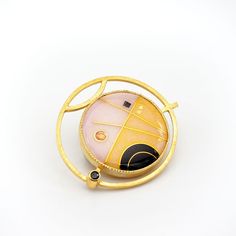 This modern convertible brooch pendant has a 24K gold cloisonne vitreous enamel on silver jewel in a geometric design with deep black, petal pink and warm yellow set into gold vermeil over sterling silver with faceted black spinel, enamel measures 1" diameter, overall 1.5" Luxury Gold Enamel Brooch, Luxury Gold Enamel Brooches, Gold Modernist Brooch For Formal Occasions, Modernist Gold Brooch For Formal Occasions, Modernist Gold Brooch Jewelry, Modernist Gold Brooch, Unique Gold Jewelry With Black Enamel, Contemporary Yellow Gold Oval Jewelry, Contemporary Oval Yellow Gold Jewelry