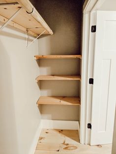 an empty closet with wooden shelves in it